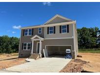 Two-story home showcasing a two-car garage and neutral color scheme against a clear blue sky at 100 Cordoba Dr, Franklinton, NC 27525