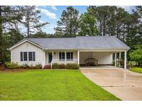 Charming single-story home featuring a well-manicured lawn and a convenient covered carport at 1000 Strobus Ct, Wendell, NC 27591