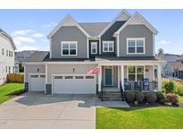 Charming two-story home with a well-maintained lawn, two car garage, and inviting front porch at 109 Obsidian Dr, Holly Springs, NC 27540