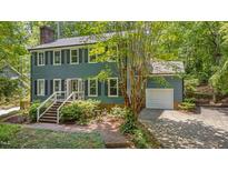 Charming two-story home features a brick walkway, mature landscaping, and a convenient attached garage at 207 Old Forest Creek Dr, Chapel Hill, NC 27514