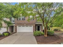 Charming two-story brick home featuring a two-car garage and well-maintained landscaping at 2073 Weston Green Loop, Cary, NC 27513