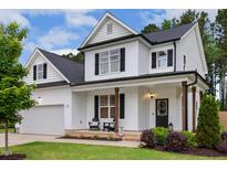 Charming two-story white home featuring black shutters, a covered front porch, and a well-manicured lawn at 22 Chapman Ct, Wendell, NC 27591