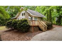 Charming home featuring stone accents, a spacious deck, and surrounded by lush greenery at 222 Sagamore Dr, Louisburg, NC 27549