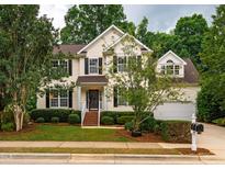 Charming two-story home features a well-manicured lawn and classic architectural details at 303 Laurens Way, Chapel Hill, NC 27516