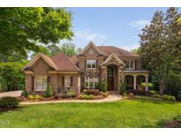 Beautiful brick and stone home with lush landscaping, a charming fountain, and a well-manicured lawn at 3601 Nightfall Ct, Raleigh, NC 27607