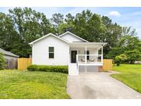 Charming single-story home featuring a welcoming front porch, landscaped yard, and a well-maintained lawn at 407 Sparella St, Durham, NC 27703