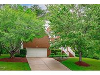 Charming brick home with a well-manicured lawn, mature trees, and a two-car garage at 408 Dairy Farm Dr, Hillsborough, NC 27278