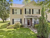 Charming two-story home features a well-manicured lawn and a welcoming front porch with brick and stone accents at 4104 Panther Creek Pkwy, Durham, NC 27704