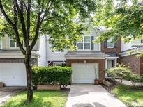 Charming two-story townhome with brick accents, a garage, and a well-manicured lawn with mature landscaping at 4206 Camden Woods Ct, Raleigh, NC 27612