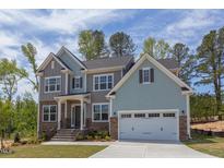 Charming two-story home with a two-car garage, stone accents, and a landscaped front yard at 45 Little Gem Ln, Fuquay Varina, NC 27526