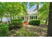Charming home exterior featuring a red-brick staircase with bright red door and mature trees at 4500 Lancashire Dr, Raleigh, NC 27613