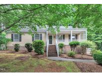 Charming single-story home featuring a welcoming front porch, brick foundation, and tidy landscaping at 5804 Heatherbrook Cir, Raleigh, NC 27612
