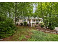 Charming single Gathering home showcasing a covered porch, complemented by lush greenery and a well-manicured lawn at 5804 Heatherbrook Cir, Raleigh, NC 27612