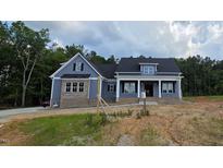 Inviting two-story home with a combination of blue siding and brick accents for a timeless exterior at 60 Stream View Way, Spring Hope, NC 27882