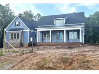 Striking new construction home with blue siding, brick accents, and a covered front porch at 60 Stream View Way, Spring Hope, NC 27882