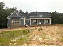 Charming craftsman-style home featuring gray siding, brick accents, and inviting front porch with columns at 60 Stream View Way, Spring Hope, NC 27882