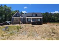 View of a newly built home, featuring gray siding, a charming dormer, and a front porch at 60 Stream View Way, Spring Hope, NC 27882
