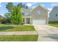 Charming two-story home with a well-manicured lawn and a spacious two-car garage at 672 Millers Mark Ave, Wake Forest, NC 27587