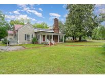 Charming home featuring a red roof, brick chimney, and a large front yard perfect for outdoor activities at 6720 Dwight Rowland Rd, Willow Springs, NC 27592