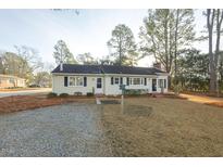 Charming single-story home featuring a gravel driveway, well-kept lawn, and classic curb appeal at 75 Hartwell Cir, Lillington, NC 27546