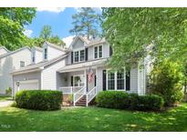 Charming two-story home featuring a manicured front yard, gray siding, white trim, and an attached garage at 9400 Leslieshire Dr, Raleigh, NC 27615