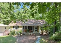 Charming single-story home with a welcoming front porch and lush, mature landscaping surrounded by trees at 96 Holly Cir, Henderson, NC 27537
