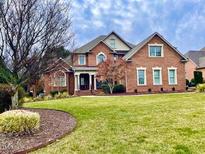 Beautiful brick home featuring mature landscaping, symmetrical windows, and a welcoming entrance, set on a well-manicured lawn at 1010 Mill Pointe Way, Elon, NC 27244