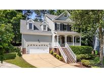 Charming two-story home featuring a welcoming front porch, dormer windows and an attached two car garage at 104 Kylesku Ct, Apex, NC 27502