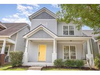 Charming two-story home features a bright yellow front door, inviting porch, and neatly landscaped yard at 10744 Cokesbury Ln, Raleigh, NC 27614