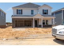 Two-story home under construction showing brick facade and an attached two-car garage at 1104 Landen Creek Ln, Zebulon, NC 27597