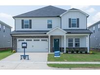 Charming two-story home featuring a brick-accented garage and a welcoming front porch at 1104 Landen Creek Ln, Zebulon, NC 27597