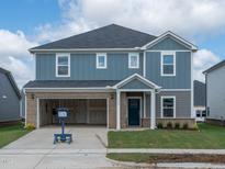 Two-story home with a two car garage, blue siding, brick accents, and well-manicured lawn at 1108 Landen Creek Ln, Zebulon, NC 27597