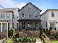 Charming gray two-story home featuring a welcoming front porch and landscaped yard at 117 Banning Dr, Pittsboro, NC 27312