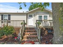 Charming single-story home with brick stairs and a cozy front porch, complemented by lush landscaping and a welcoming front door at 12294 Nc Hwy 96 S, Dunn, NC 28334