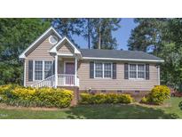 Charming single-Gathering home with neat front yard landscaping, dark shutters, and a cozy front porch at 133 Parkhaven Ln, Garner, NC 27529