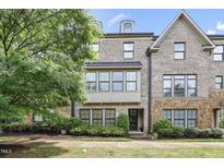 Attractive brick townhome featuring a covered porch and manicured landscaping at 1602 Bowery Dr, Raleigh, NC 27607