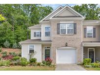 Charming townhome with a manicured lawn, attached garage, and a mix of brick and siding at 161 Walking Path Pl, Hillsborough, NC 27278
