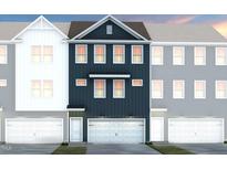 Modern townhouse with a two-car garage and beautiful navy blue siding between white and grey units at 2137 Grouse Ski Cir, Apex, NC 27523