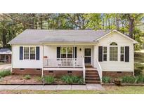 Charming single-story home with a cozy front porch and well-maintained landscaping in a quiet neighborhood at 300 Plantation Rd, Clayton, NC 27520