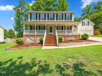 Charming two-story home with a welcoming front porch and landscaped front yard at 3025 Creek Moss Ave, Wake Forest, NC 27587