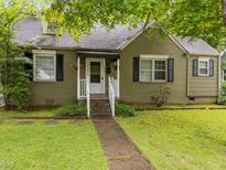 Charming brick home with black shutters, manicured lawn, and a welcoming front porch with flower boxes at 313 Colleton Rd, Raleigh, NC 27610