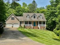 Charming home with a manicured lawn, bright blue front door and three dormer windows above the front porch at 327 Beavertail Rd, Henderson, NC 27537