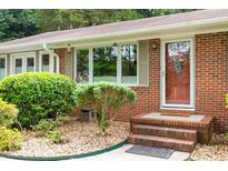 Charming brick home featuring a welcoming front door and landscaped garden at 3515 Luna Ln, Durham, NC 27705