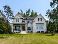Stunning new construction, two-story home with white siding, black shutters, and a well-manicured lawn at 4104 Bankshire Ln, Raleigh, NC 27603