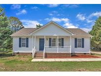 Charming single-story home with blue shutters, inviting front porch, and manicured landscaping at 430 Sir David Dr, Zebulon, NC 27597