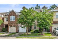 Beautiful townhouse with a two-car garage and manicured lawn at 520 Camden Yards Way, Cary, NC 27519