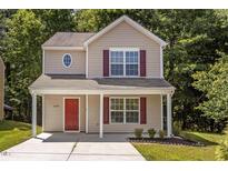Charming two-story home with red door and shutters and landscaped front yard at 6604 Frogstool Ln, Raleigh, NC 27610