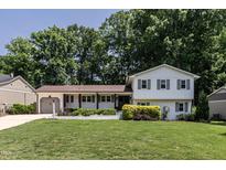Charming two-story home with well-manicured lawn, lush landscaping and attached garage at 813 Faulkner Pl, Raleigh, NC 27609