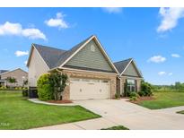 Charming single-Gathering home featuring brick and siding with an attached two-car garage and a well-manicured lawn at 839 Old Towne Dr, Elon, NC 27244
