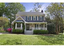 Charming two-story home featuring a well-manicured lawn, front porch, bay window, and beautiful landscaping at 8608 Cheerful Ct, Raleigh, NC 27615